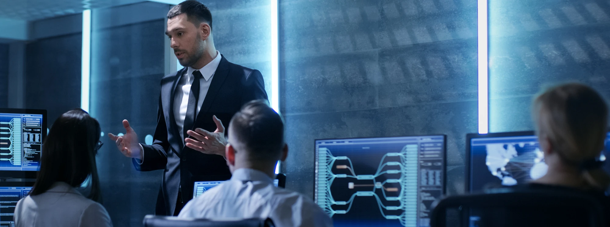 Professional giving a cybersecurity briefing with digital screens in a modern office setting.