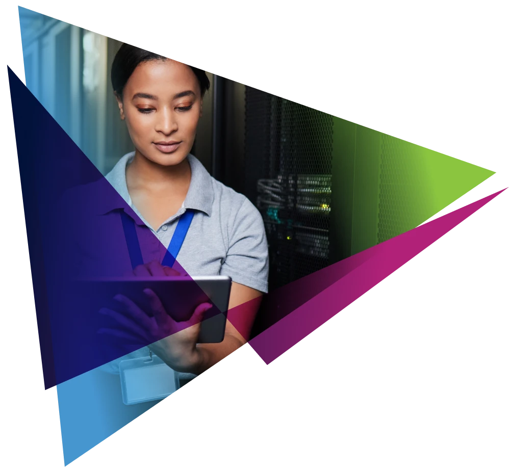 Tech professional using a tablet in a data center with colorful geometric overlay.