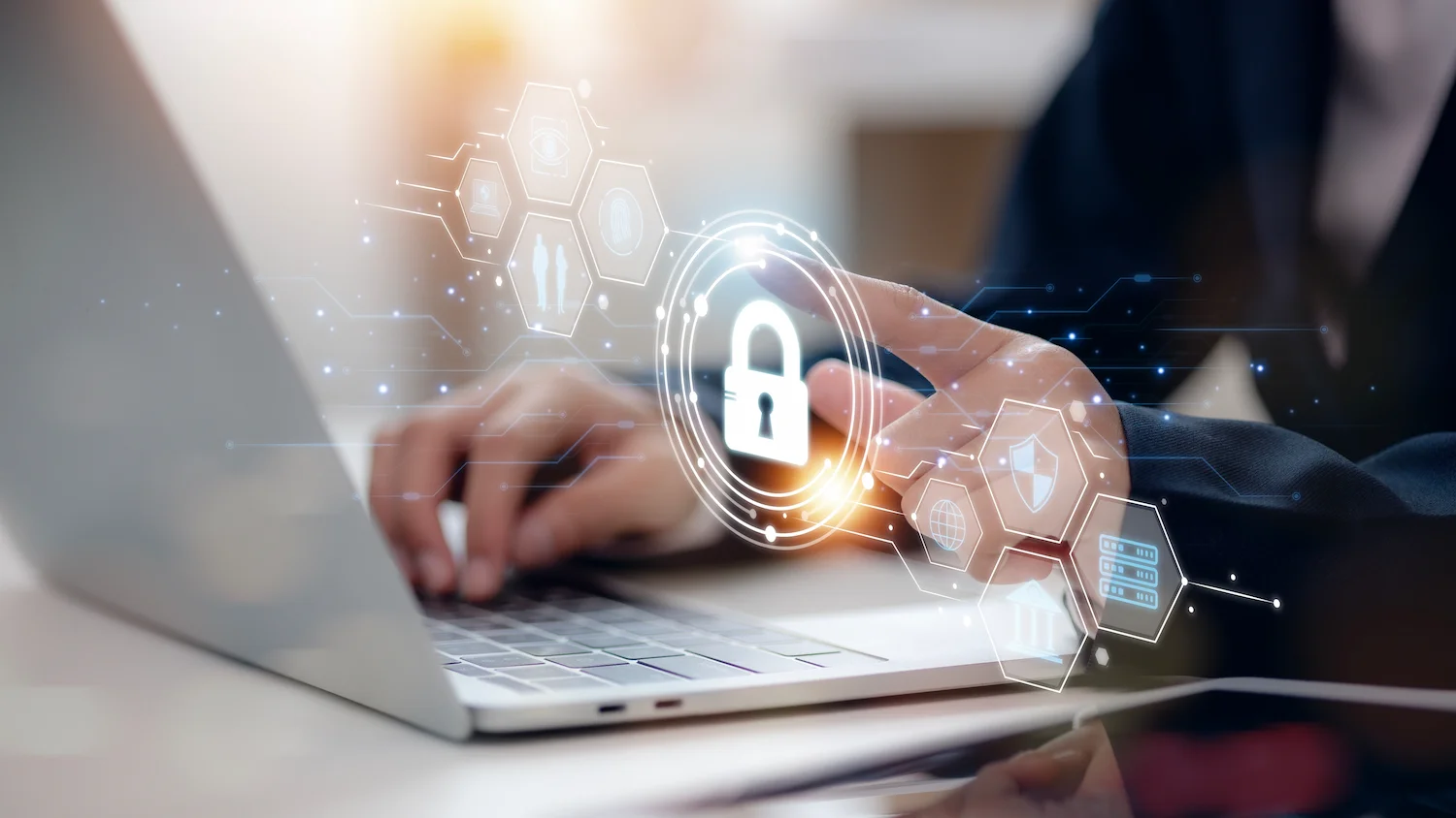 Person using laptop with digital cybersecurity interface, lock icon highlighting online data protection.