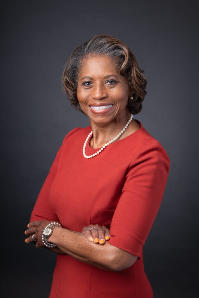 Professional headshot of a black woman in a bright red dress
